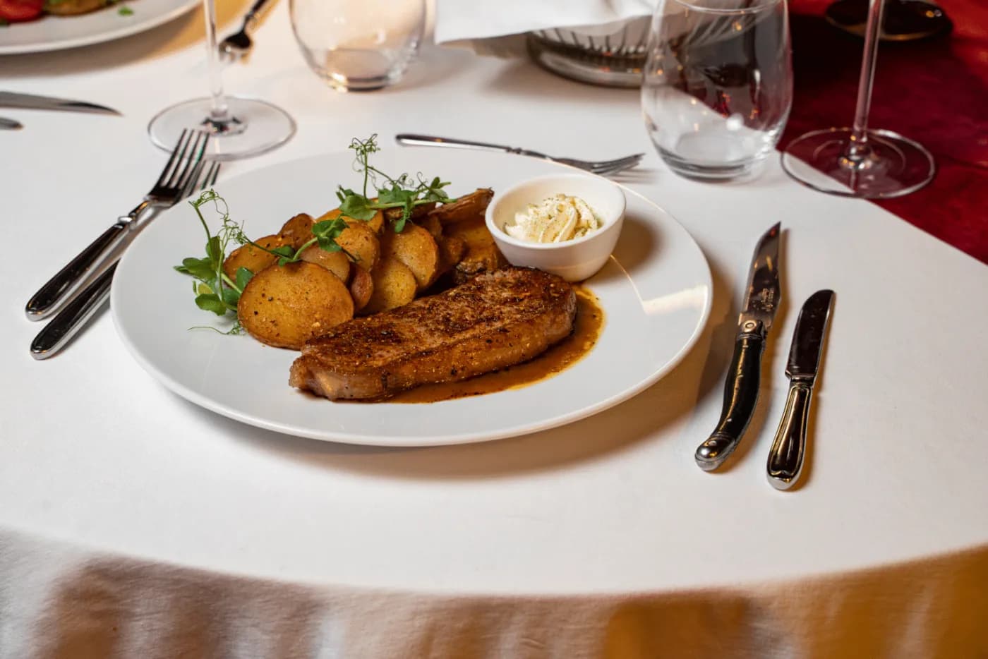 Klassisches Menü – Rib Eye Steak mit Kräuterbutter und hausgemachten Chips